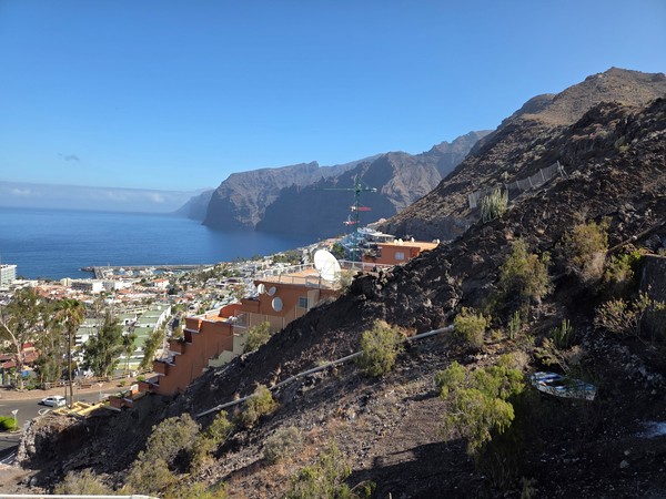 Mirador de Los Gigantes Vista panorámica de Los Gigantes desde un mirador en la ladera, con el acantilado, el mar y parte del pueblo al fondo.