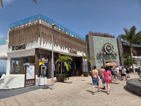 Monkey Beach Club Tenerife Fachada del Monkey Beach Club en Tenerife, con diseño moderno y turistas caminando cerca de la entrada.