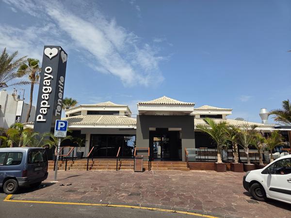 Papagayo Tenerife Exterior del club Papagayo en Tenerife, con palmeras y letrero vertical distintivo.