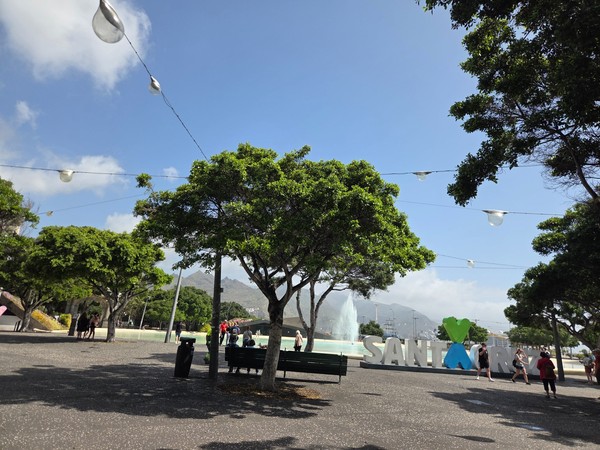 Plaza en Santa Cruz Plaza arbolada en Santa Cruz con fuente, personas paseando y el gran letrero decorativo de la ciudad.